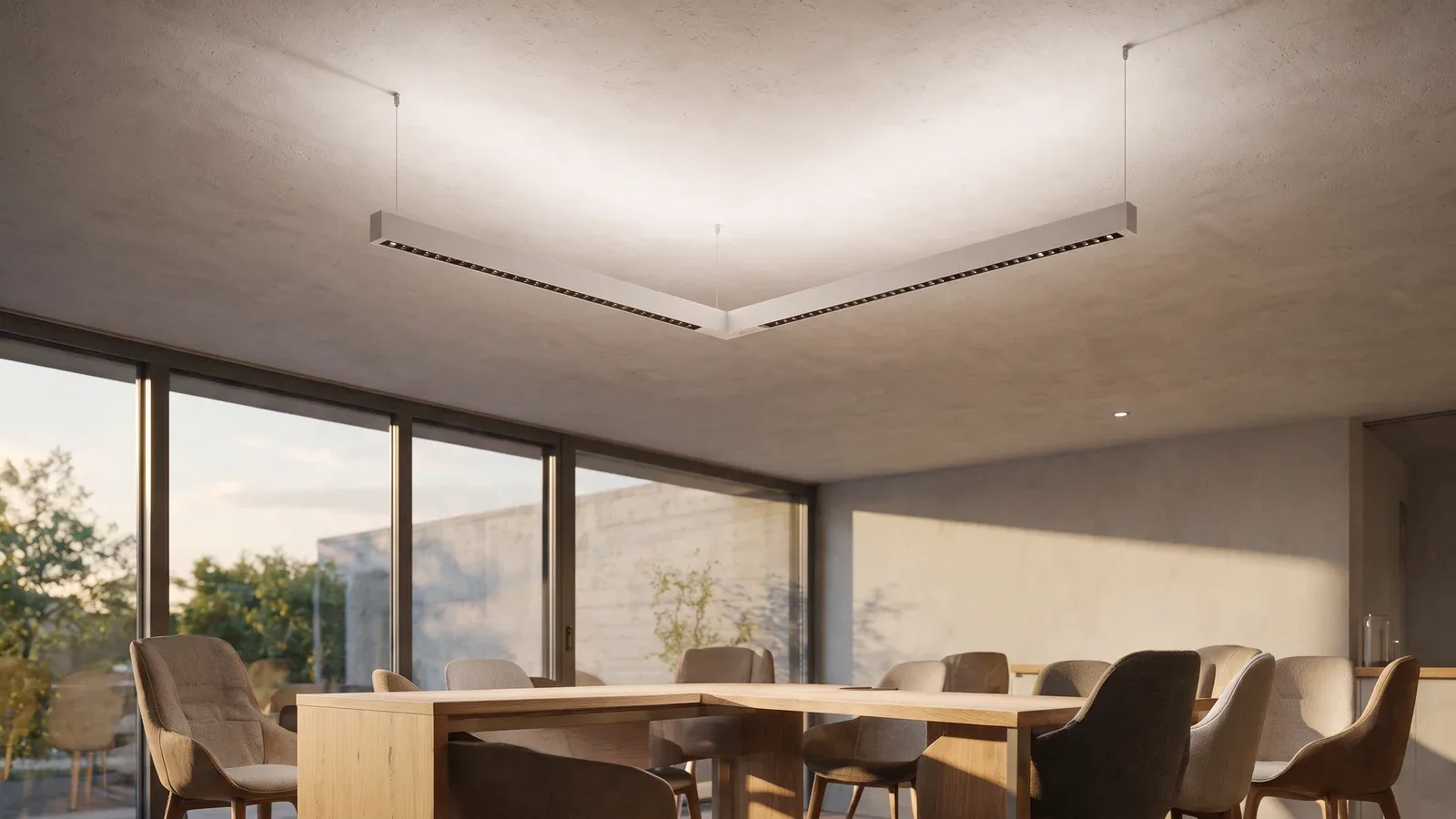 Espace collaboratif avec profils blancs en L suspendus, lumière vers le bas et doux retour lumineux au plafond.